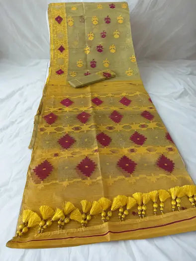 A yellow and gold saree with red geometric patterns and a matching yellow blouse piece, laid out on a white fabric background.